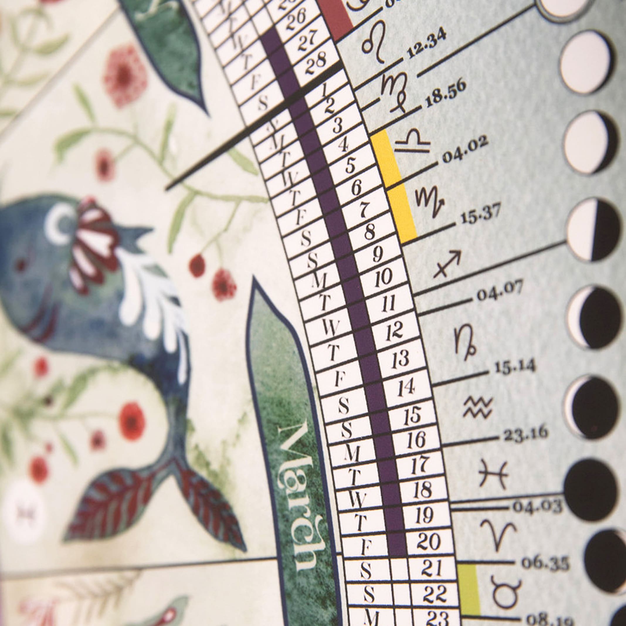 Close-up of a calendar with astrological symbols and a decorative design.